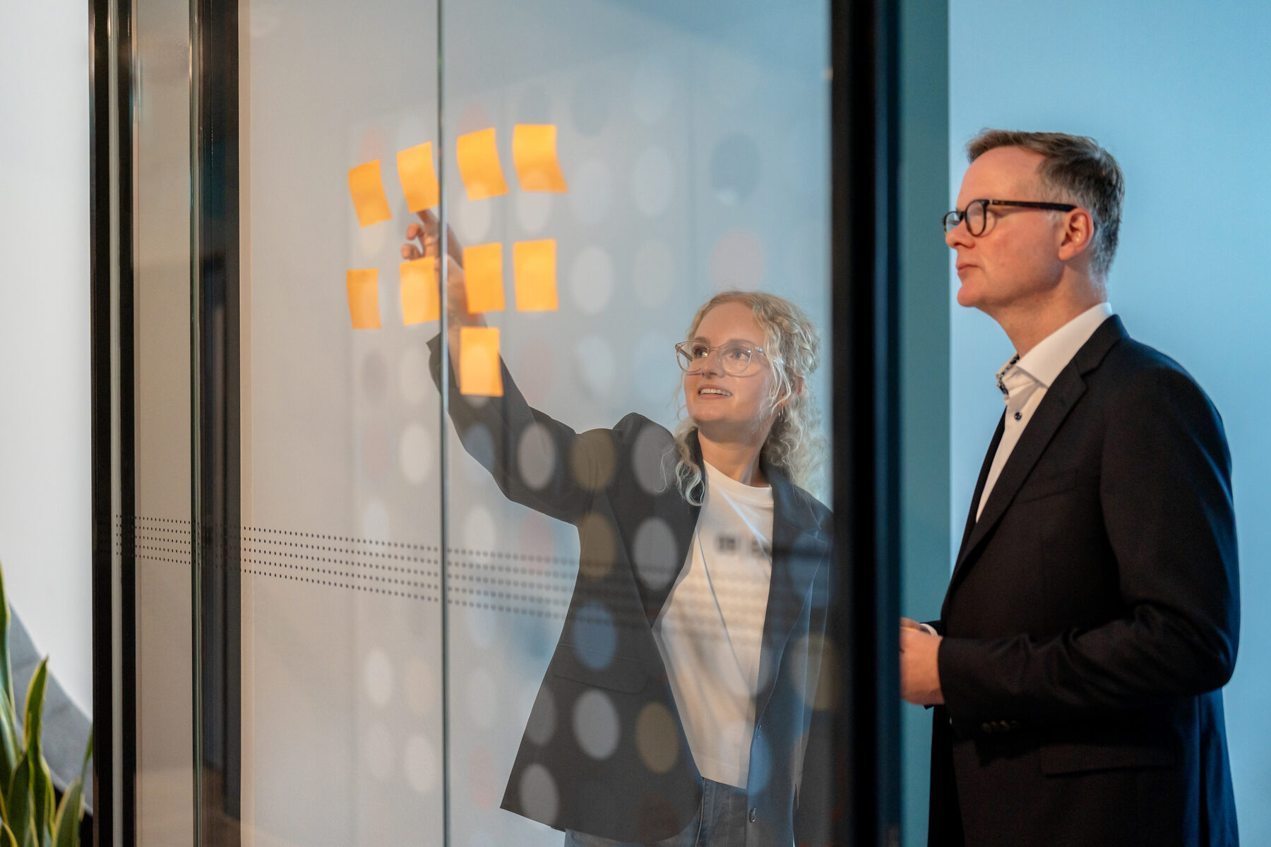 Zwei Menschen von TTE Strategy entwickeln gemeinsam Ideen an einer Workshop-Wand.